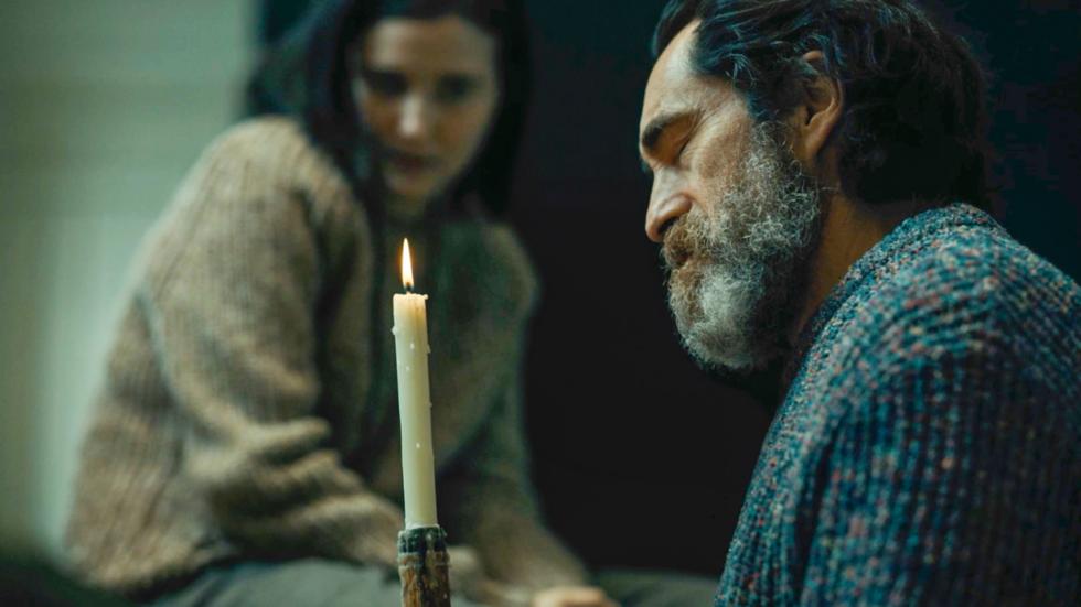 Emiily and Ismael listen to music with a single candle burning
