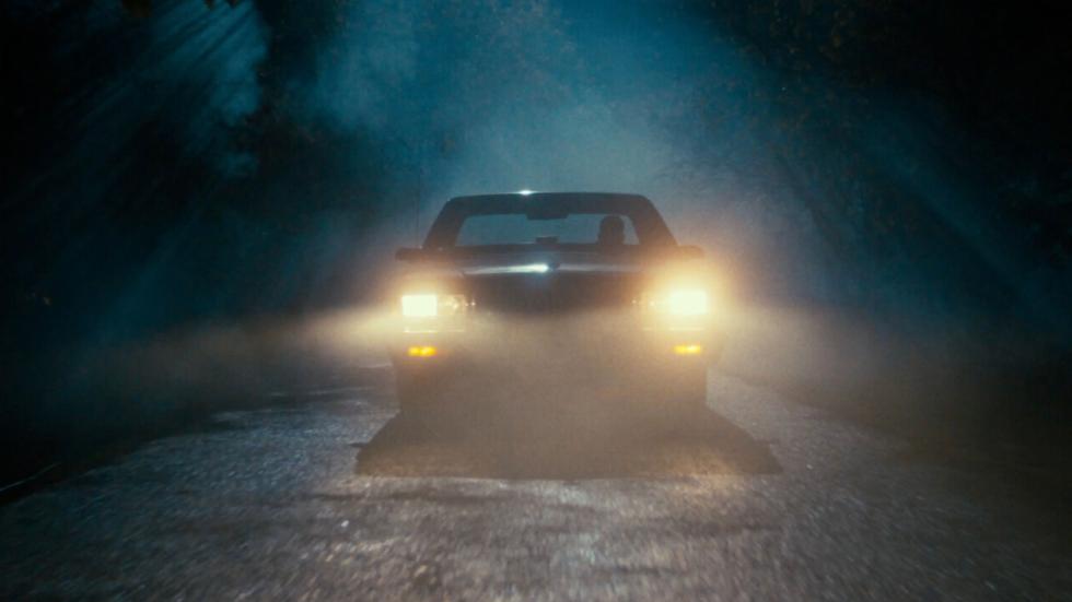 Car lights shining through the foggy night
