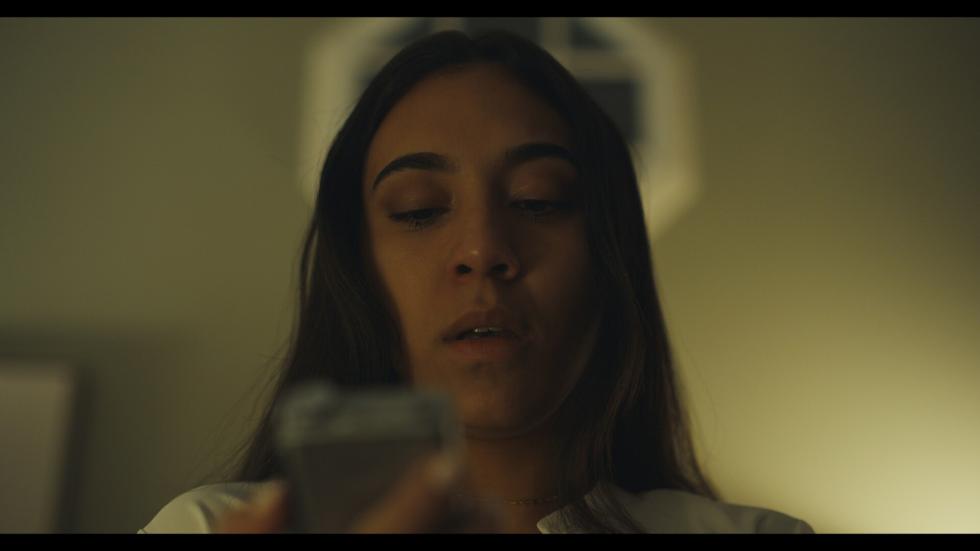 A young woman looks at her cellphone