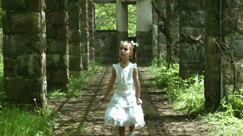 The Captured Bird little girl walking among castle grounds