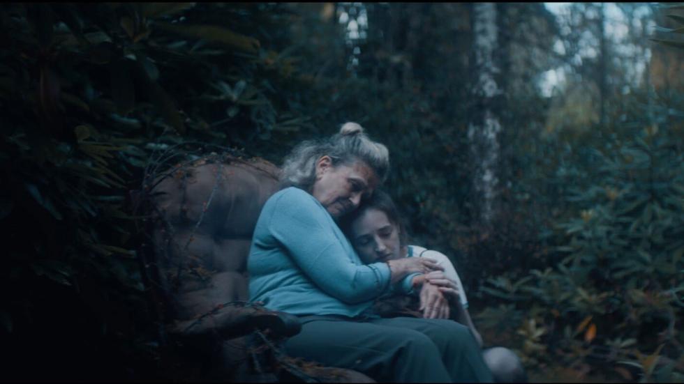 FIONA and MAEVE sit in a chair in the woods