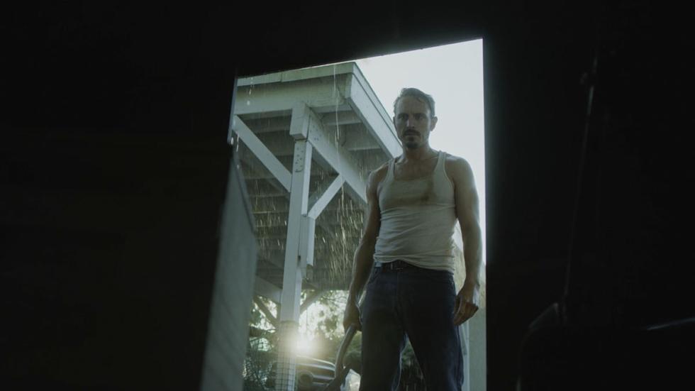As Long As You Both Shall Live film still man in wife beater shirt with hammer