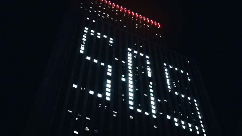 Alone film still SOS spelled out in lights on a sky scraper