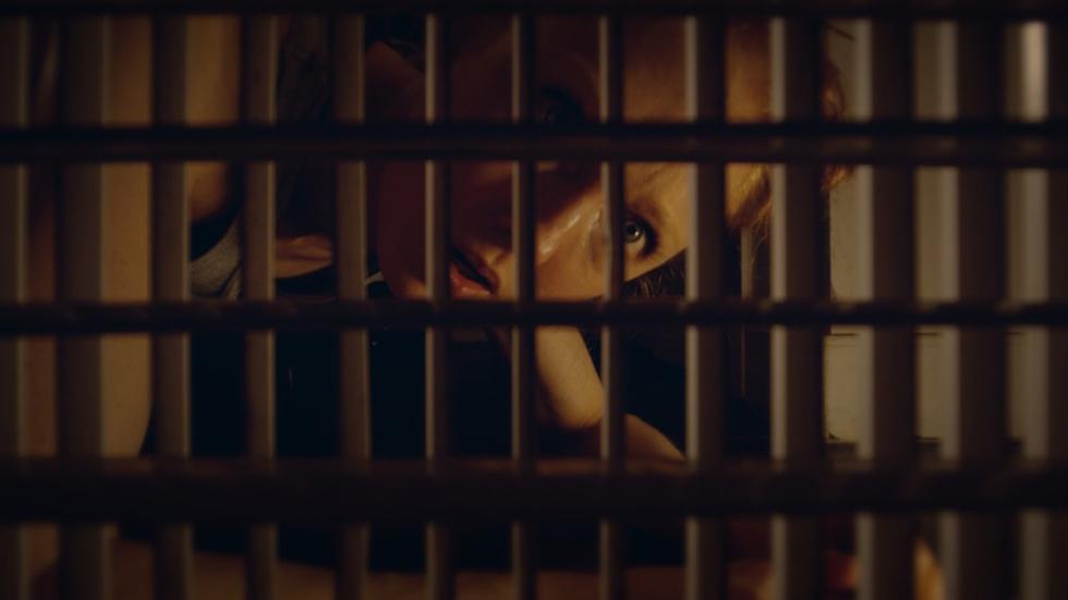 Woman looking through grate