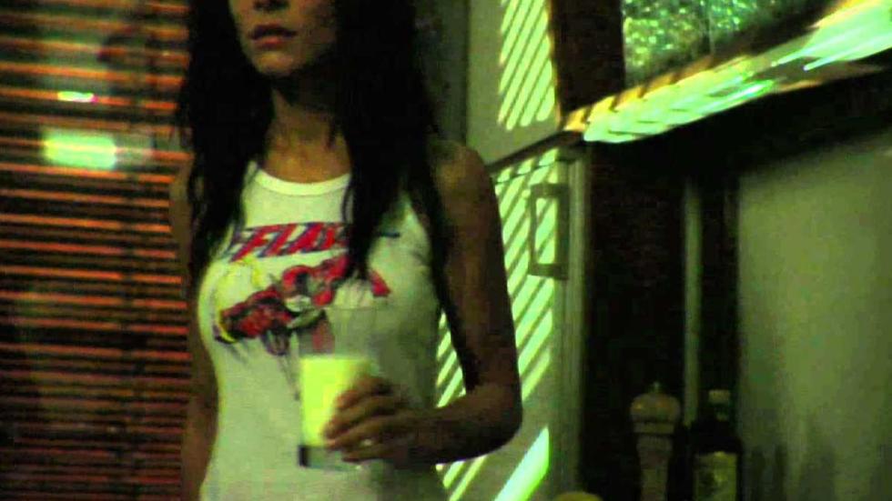 Anyone There? woman in tank top walks with a glass of milk