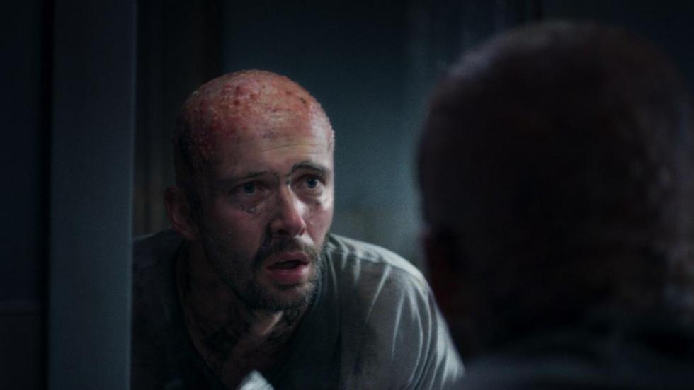 Bad Hair film still bald man looks at himself in the mirror