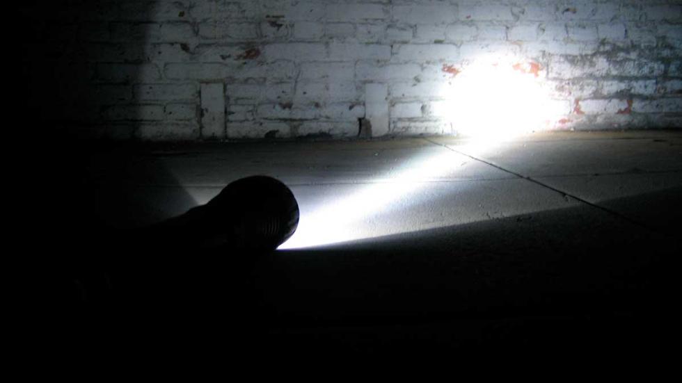 Becoming flashlight shines on brick wall