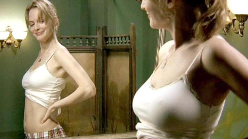 Blessed Samantha is looking at her pregnant belly in the mirror