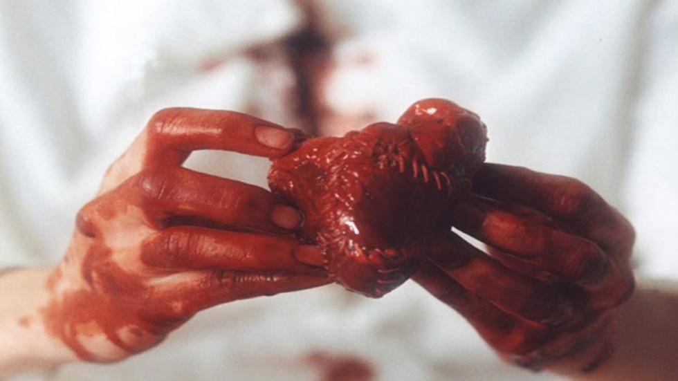Broken a woman sews a bloody heart with her bloody hands
