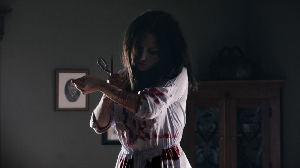 Cauchemar Capitonné film still woman slashes her arm with scissors