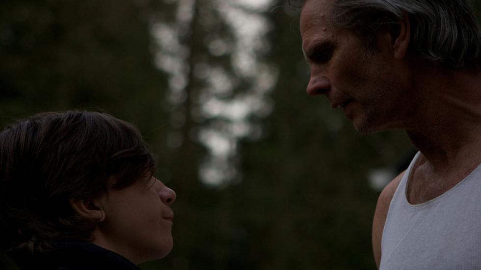 Chained Peter and his father talk in the woods