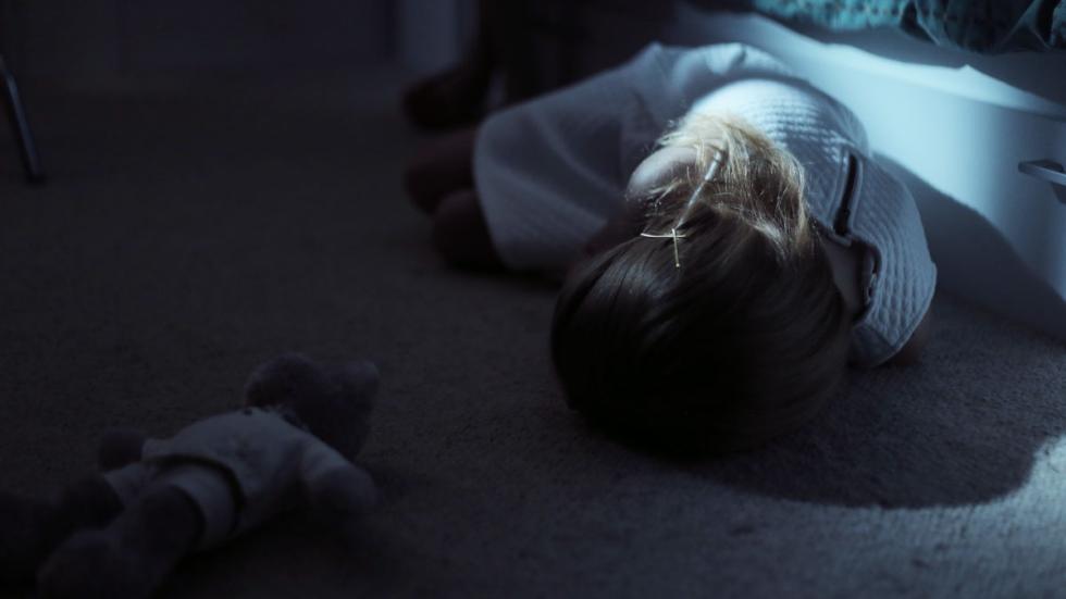 Charlie film still child lays on the ground