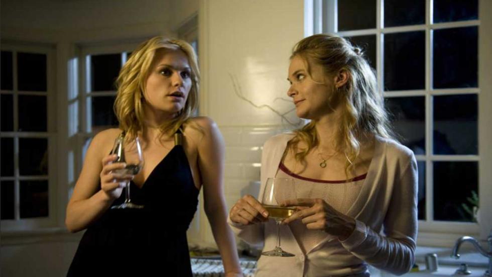 Darkness Two women talk in the kitchen while drinking a glass of wine