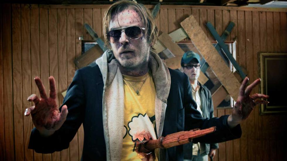 Deadheads man stands with wooden stake in his stomach