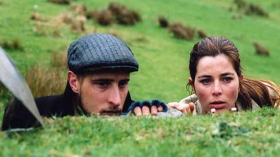 Dead Meat A man and woman peek out beyond a grassy hill