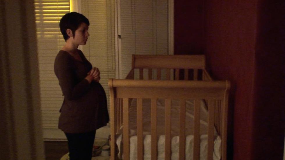 Delivery pregnant woman looks at crib