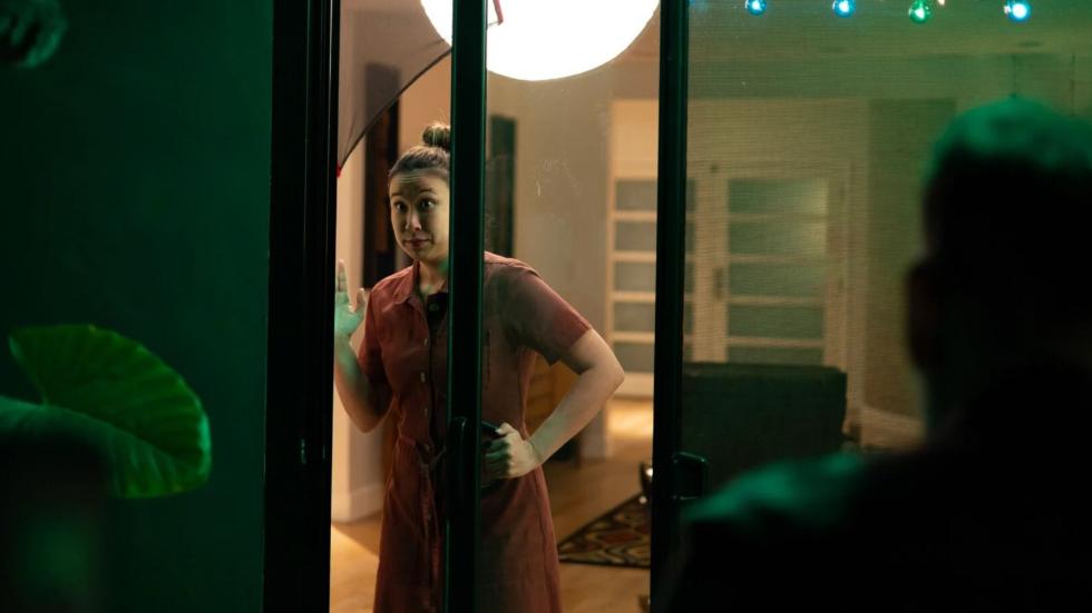 A woman looks out of her sliding glass door