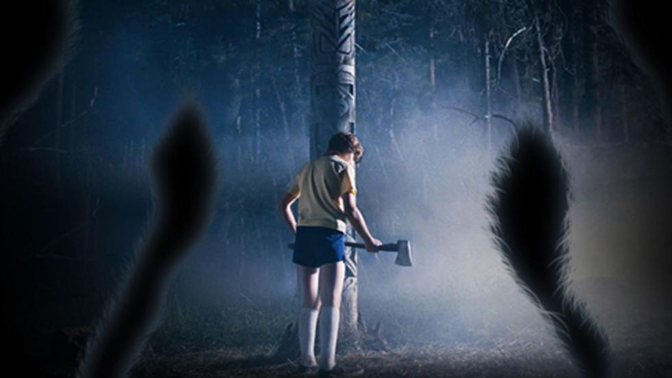 Eaglewalk young boy walks with an axe in the woods