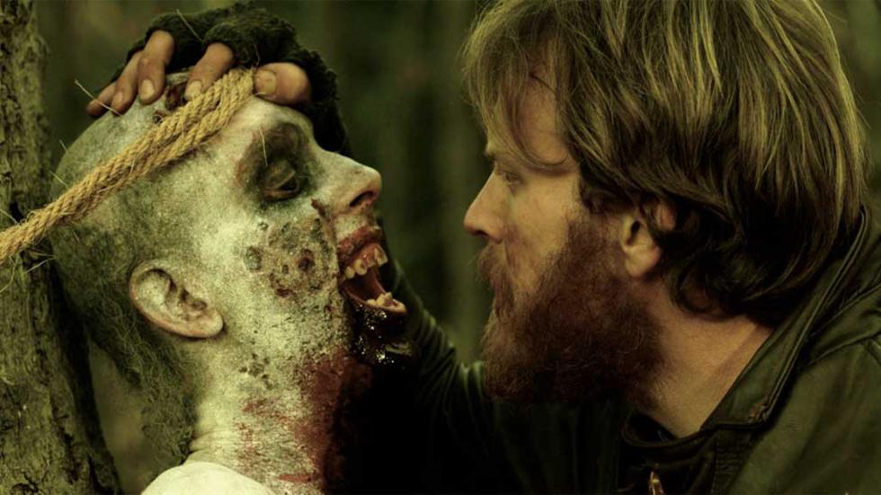 Exit Humanity man looks at tied up creature man