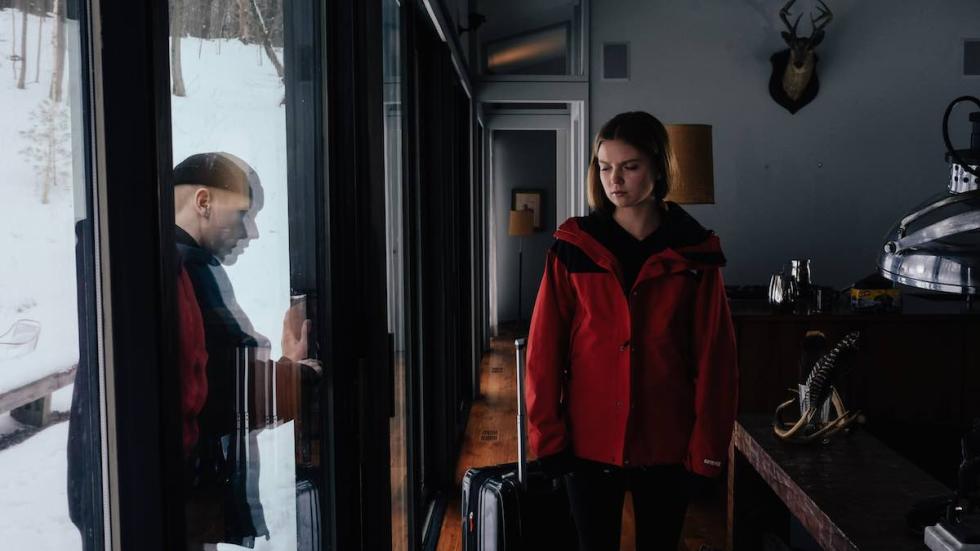 Glass Cabin film still woman watching man trying to unlock sliding door.