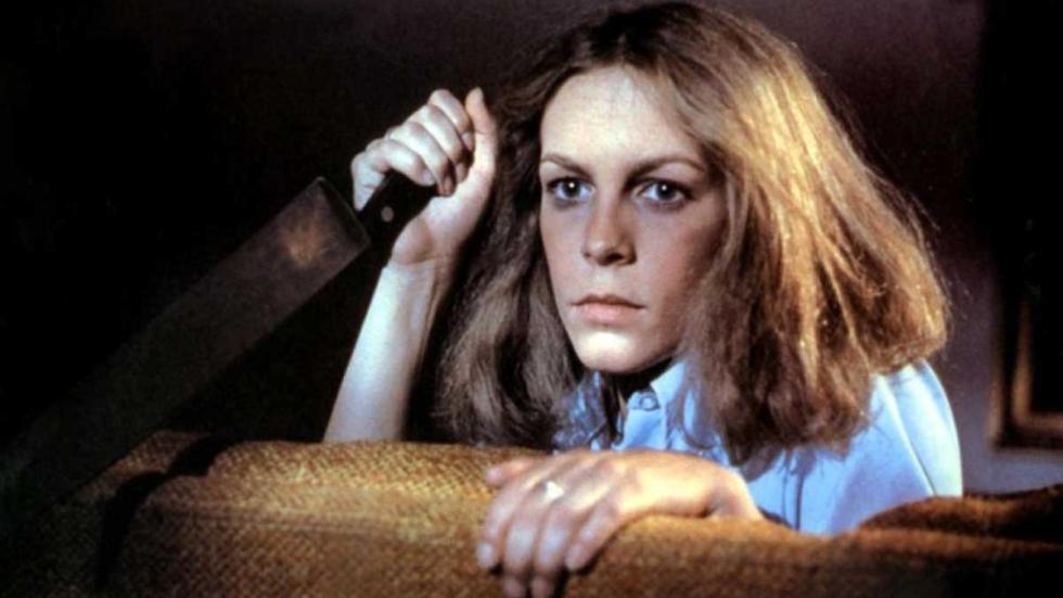Halloween Laurie holds a knife sitting on a couch waiting for Michael