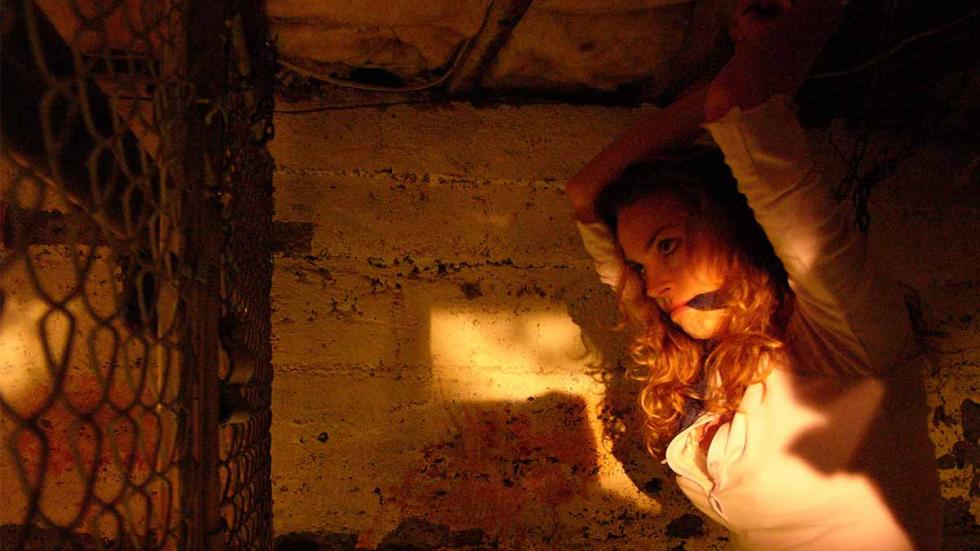 The Hamiltons a woman is gagged and locked in a cage