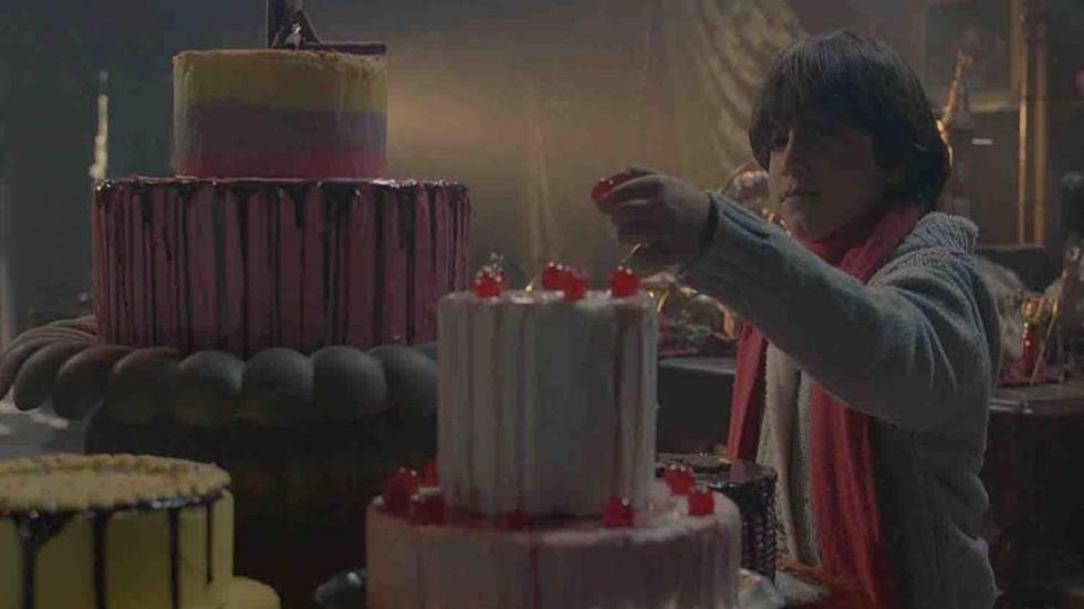 Boy taking candy from a cake