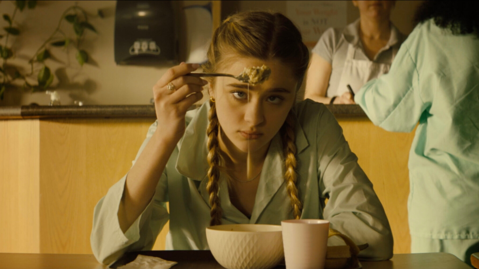 Bored looking young woman plays with her food