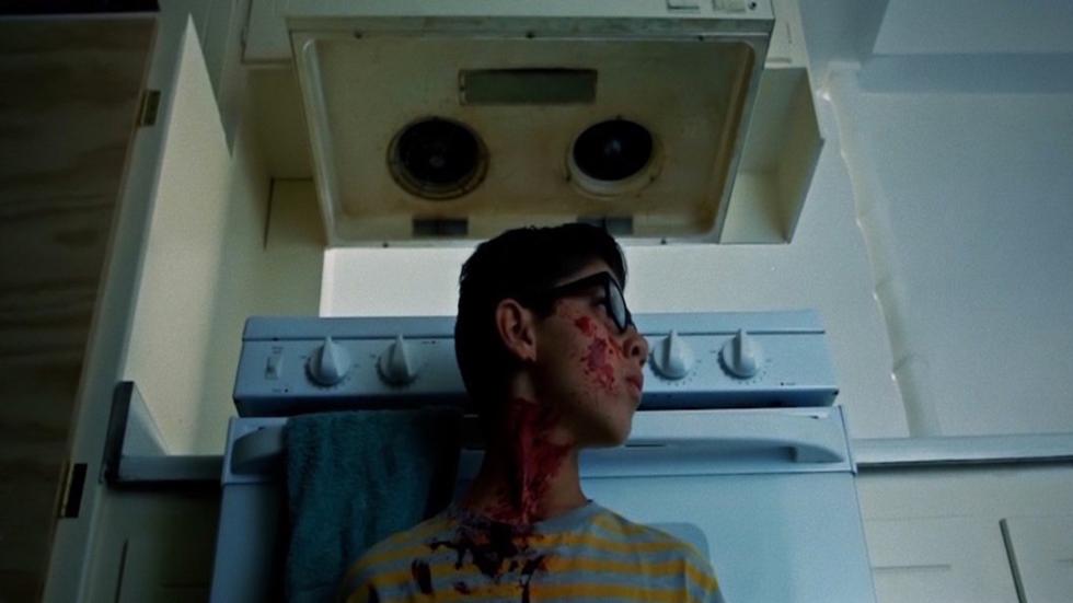 It Began Without Warning film still bloody young man with glasses hiding