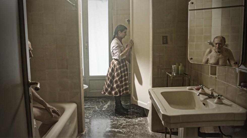 Imaginary Portrait film still young woman opening a door in the bathroom with creepy man in the bathtub
