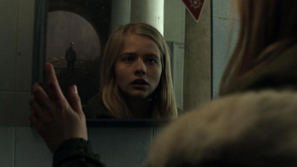 The Soul Conductor film still young woman looks at herself in the mirror.