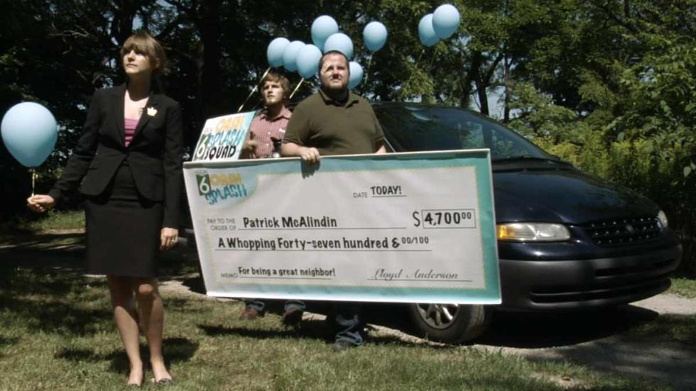 It Could Be You group of people present a check to the winner
