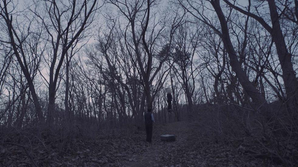 LeaveWork film still man in the woods with a box