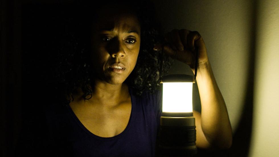 Knock Knock film still woman with a lantern in the dark