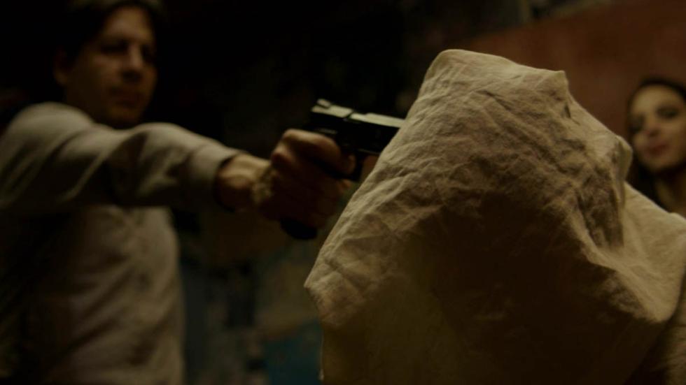 Inicuo: The Brotherhood man with a gun points at man head