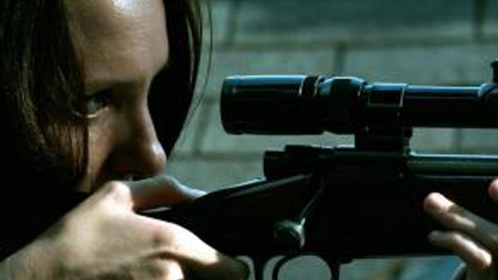 Leftovers woman looks through scope on rifle