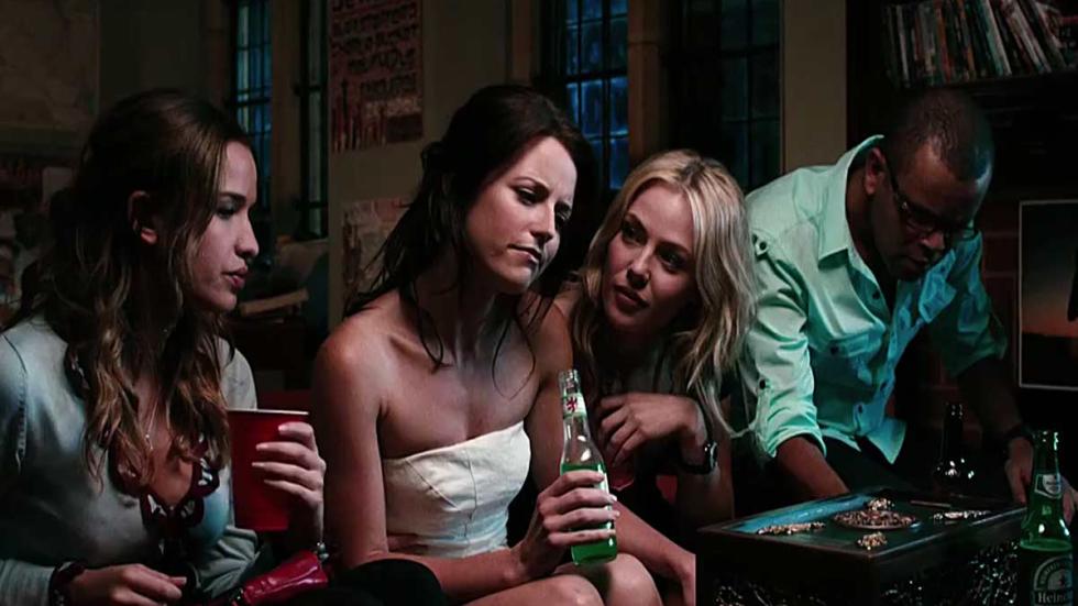 Needle woman sitting on a couch drinking and talking at a party