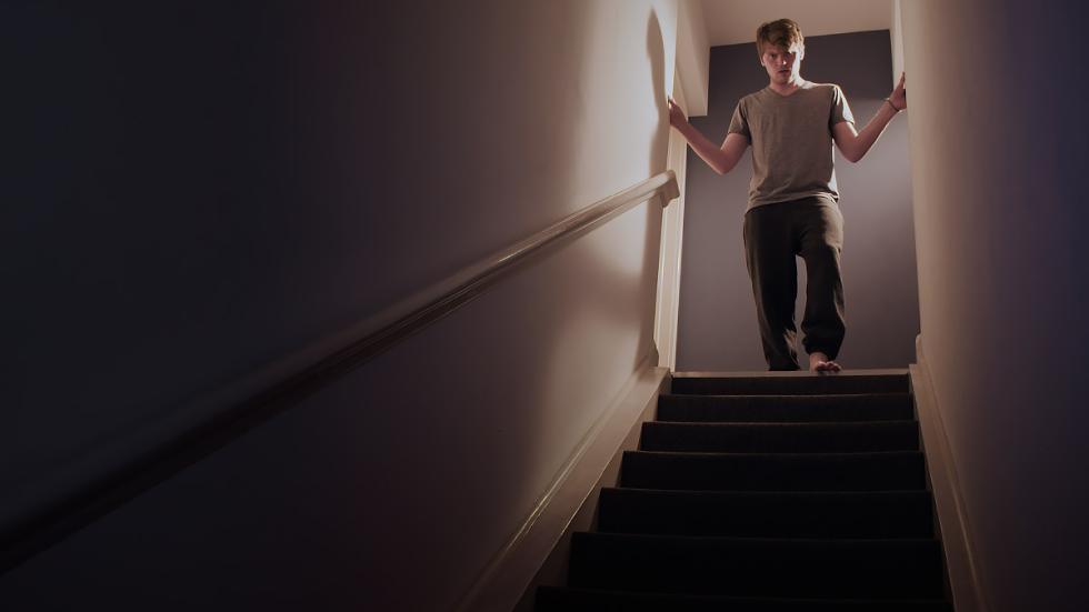 Ouroboros film still man looks down staircase