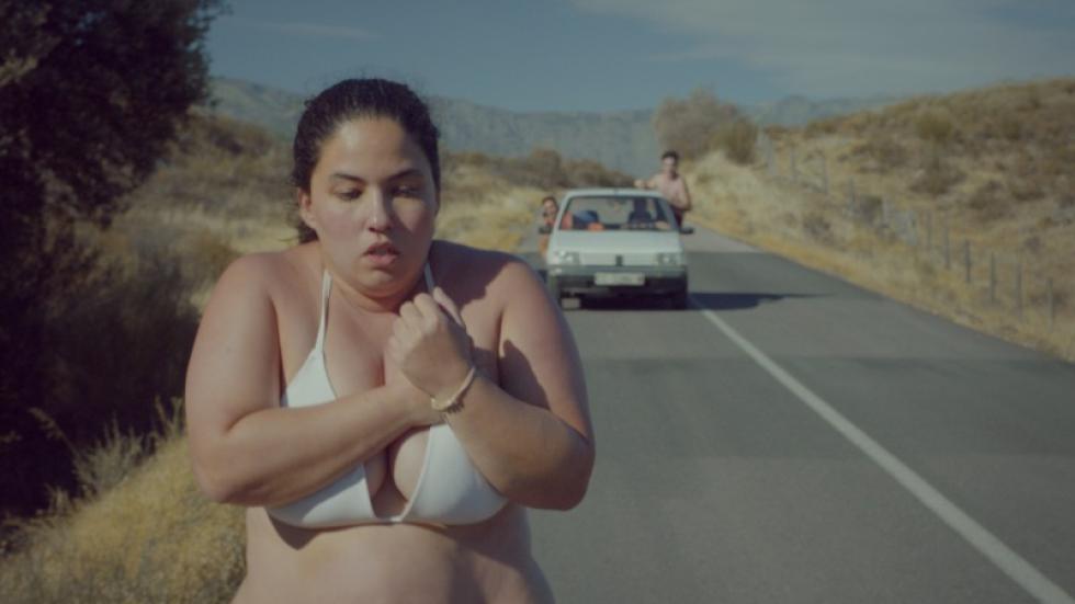 Piggy film still overweight young woman running in her bra and panties with a car behind her