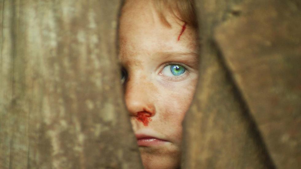 Little Boy Blue film still boy with bloody nose looking through door