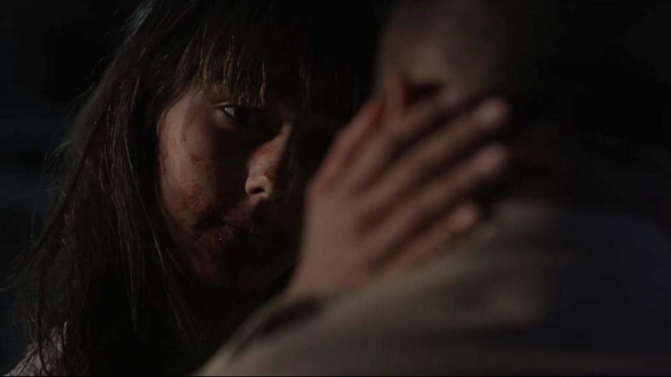 Thirteen bloodied faced young woman holds face