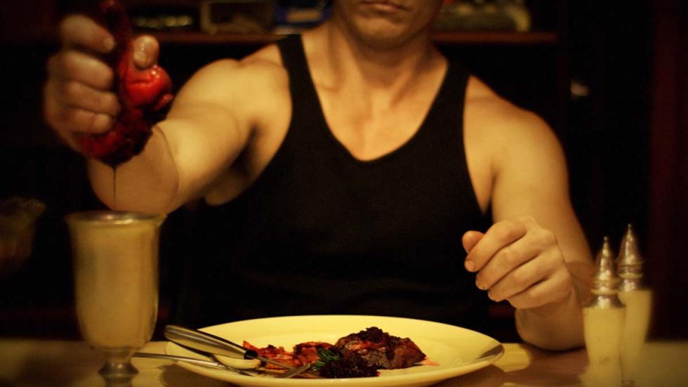 BLOOD TRAIL film still man squeezes blood from a human heart