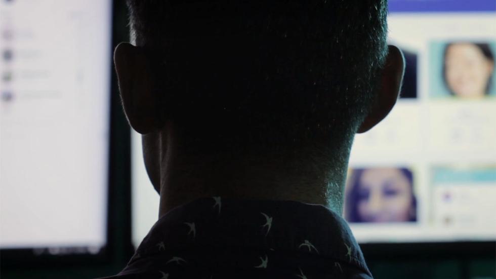 Serial Dating film still of man looking at online dating profiles