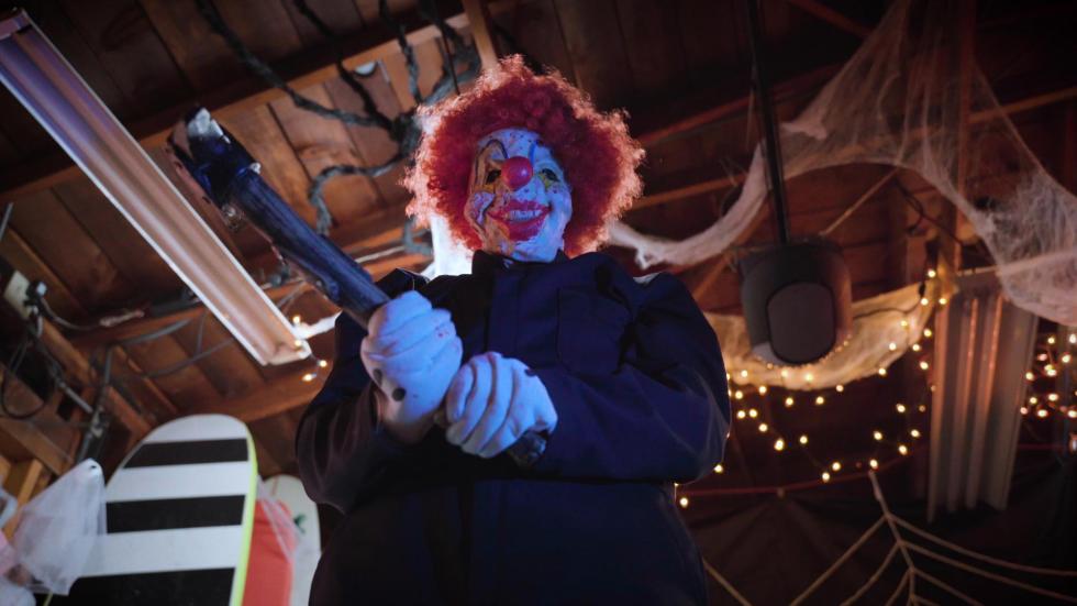 Creepy clown holds a hamemr