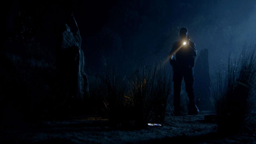 Slaughter At Lonesome Rock film still man with a flashlight in the dark