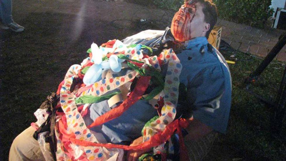 Some Guy Who Kills People dead fat man sits in a chair with birthday decorations on him