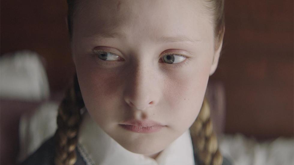 So She Might Live young girl with braided pigtails looks ominous