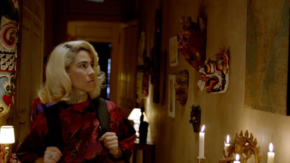 Hostile film still woman looking around home with candles