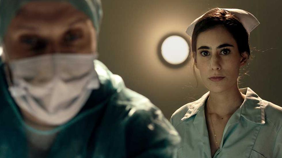 Surgery doctor looks down at patient with nurse behind him