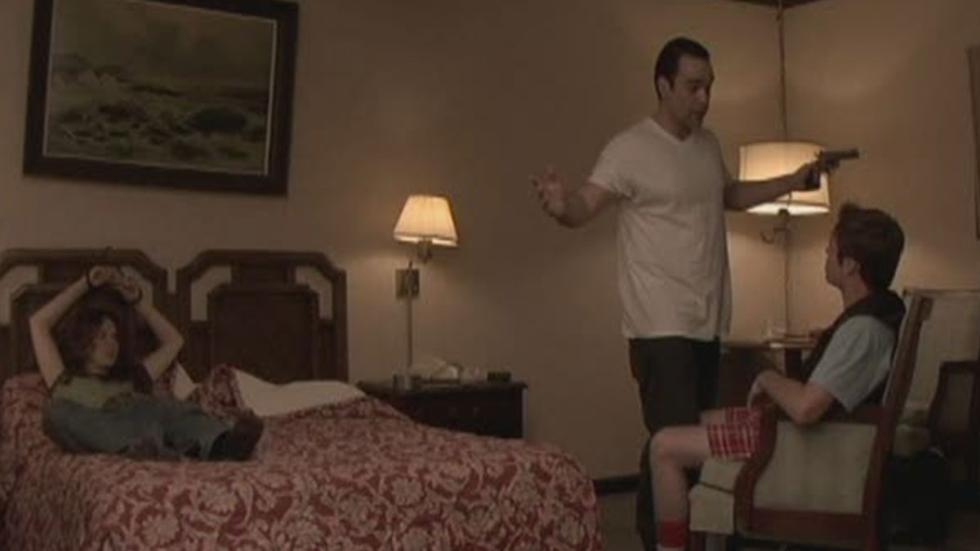 Sympathy man with a gun talks to people tied up